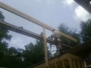 Carpenter setting a ridge beam over a new addition frame — Ice Dam Removal by Roofing Brothers in Center Conway