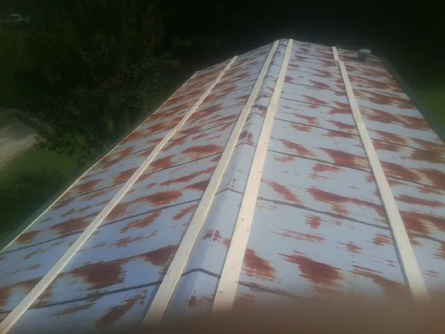 Rusted metal roof panels with new wood purlins before replacement — Storm Damage Roof Repair in Center Conway by Roofing Brothers