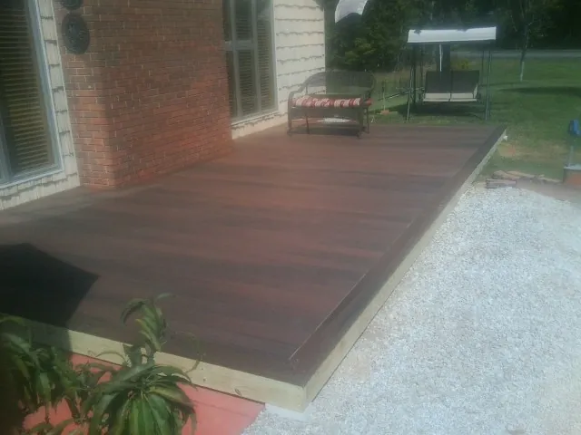 Freshly stained wood deck built against a brick home in Center Conway