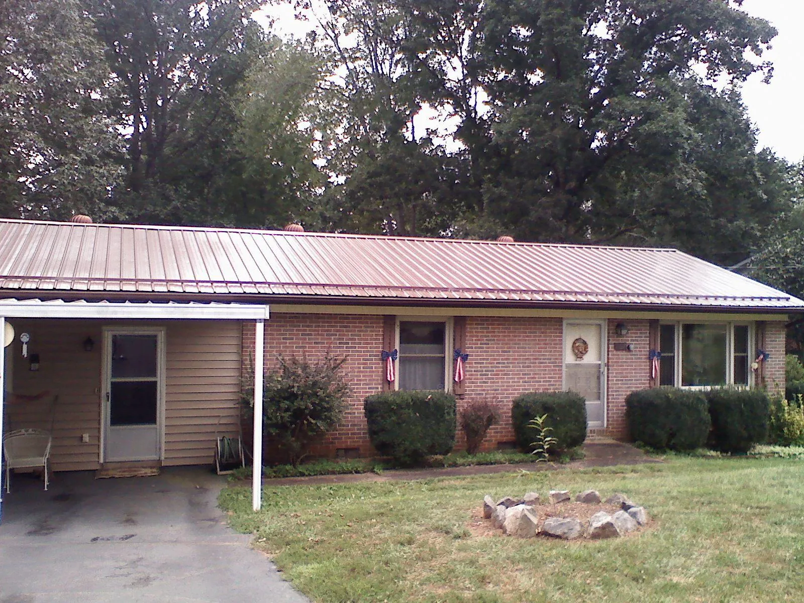 Bronze metal roof and carport on a brick ranch home — Roof Repair work by our crew in Center Conway